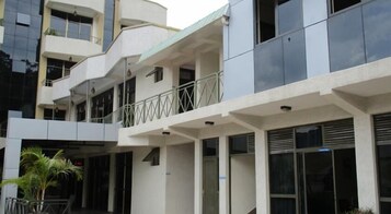 Un edificio de varios pisos con balcones, ventanas grandes y techo plano.