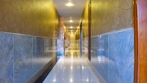 A modern hotel corridor with reflective marble walls and a polished floor. - Wuduria Hotel (Nairobi)