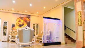 A lobby with ornate furniture, a large mural, and a decorative fountain. - Wuduria Hotel (Nairobi)
