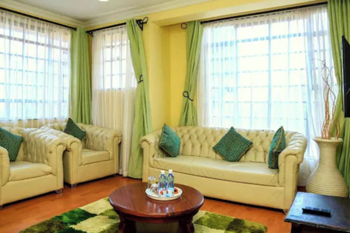 A living room with two beige sofas, a coffee table, and a green rug.