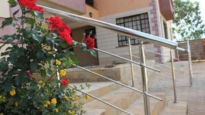 A staircase with metal railings, leading to a building with a window and a door. - Davis Court Nyeri (Nyeri)