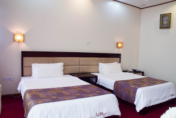 A hotel room with two beds, a wooden headboard, bedside lamps, and a telephone on the nightstand. - Lake View Resort Hotel (Mbarara)