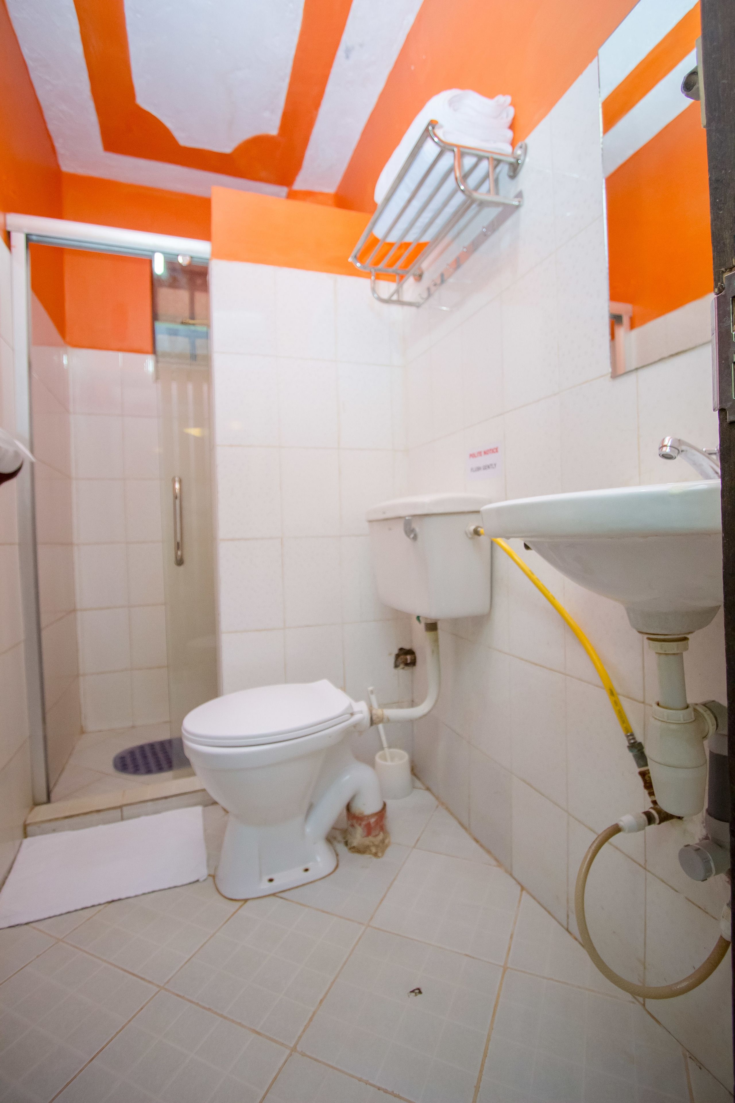 Een badkamer met toilet, wastafel en douche.