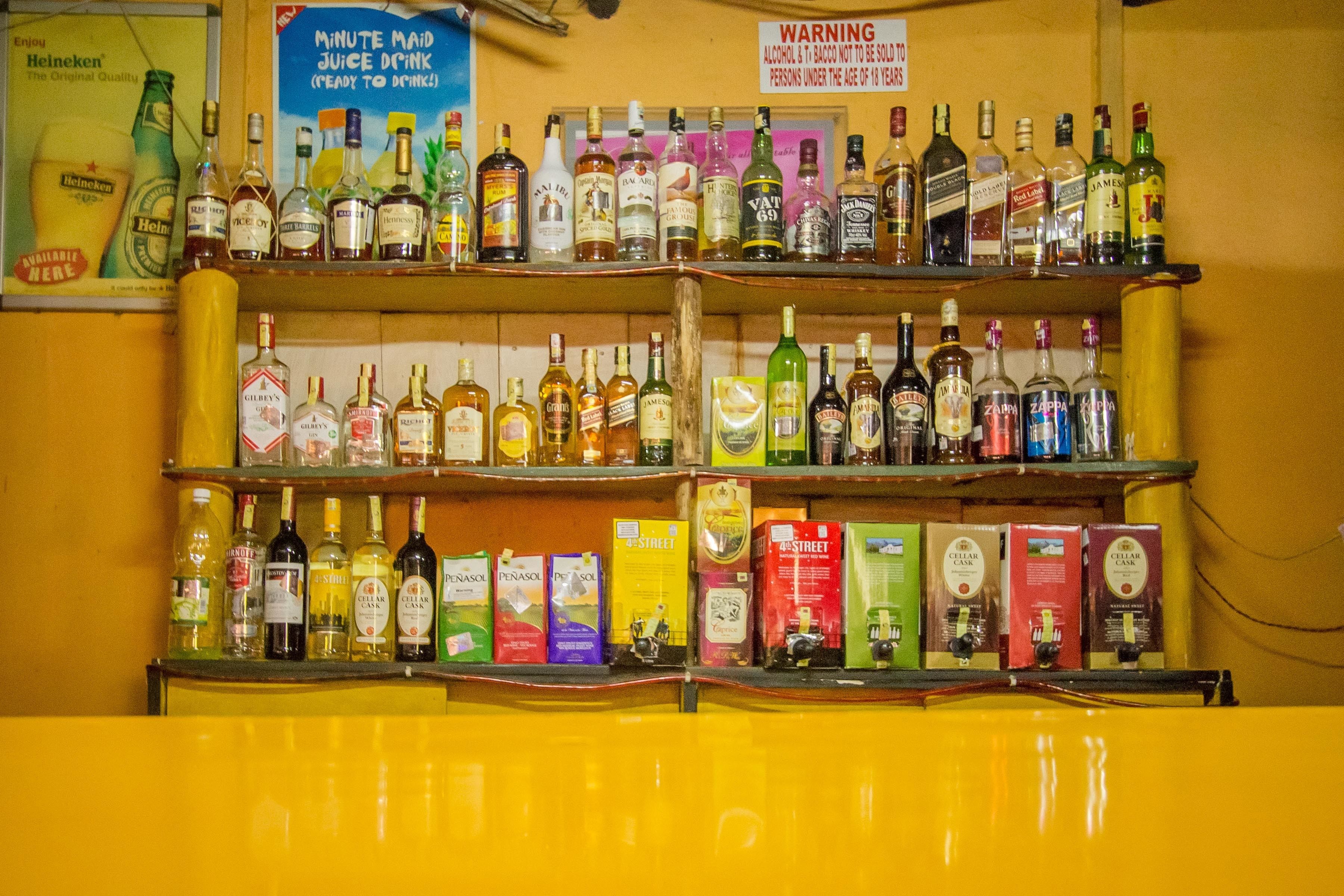Eine Bar mit zahlreichen Regalen voller Spirituosenflaschen und Bierkisten.