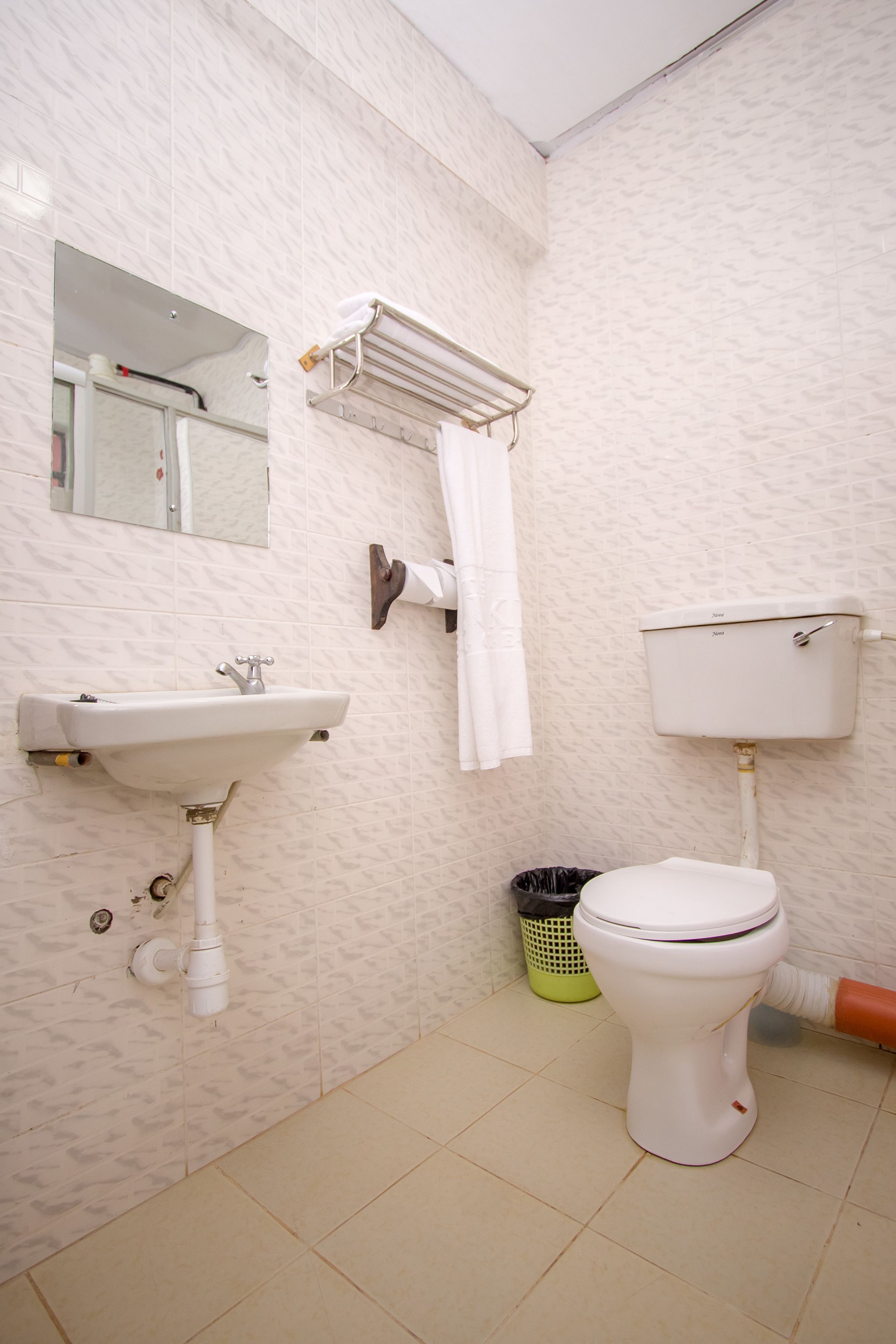 A bathroom with a sink, toilet, and a mirror.
