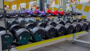 A gym with rows of dumbbells and weight plates.