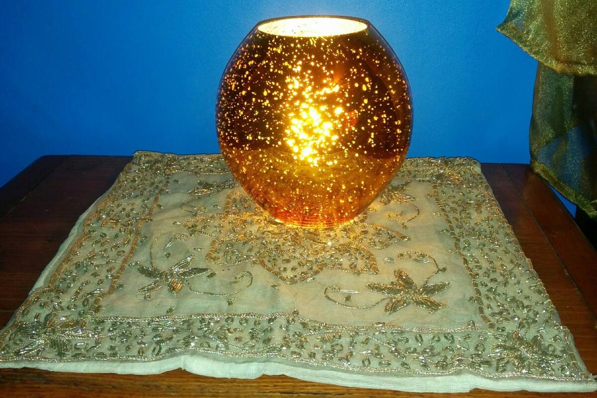 Une lampe décorative posée sur une nappe en dentelle.