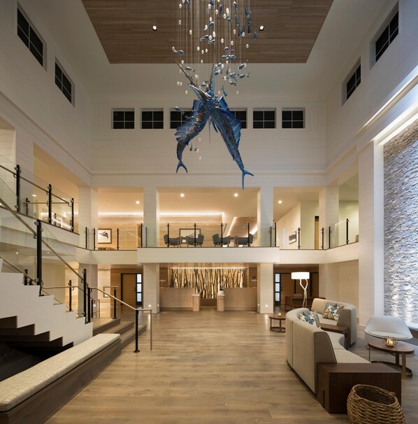 A spacious lobby with a high ceiling, a large chandelier, and a central seating area.
