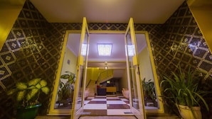 A hotel entrance with a checkered floor, a staircase, and potted plants. - Hotel Royal Nest (Entebbe)
