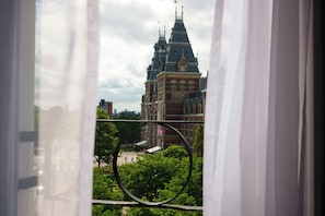 A view of a historic building with a prominent tower and a circular window frame.
