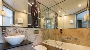 Un baño moderno con un lavamanos grande blanco, un inodoro y una bañera.