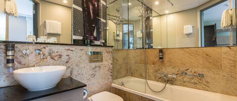 A modern bathroom with a large white sink, a toilet, and a bathtub.