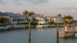 A waterfront property with a dock, a boat, and houses with a view of the water. - The Sandpiper Inn & Cottages (Crossing Rocks)