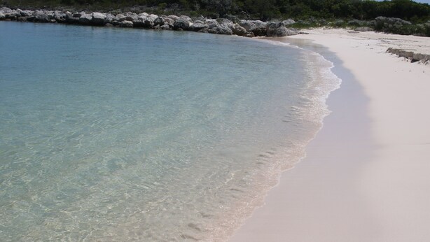 A beach with clear turquoise water, white sand, and rocky outcrops. - The Sandpiper Inn & Cottages (Crossing Rocks)