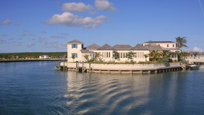A waterfront property with a dock extending into the water, featuring multiple buildings with a consistent architectural style. - The Sandpiper Inn & Cottages (Crossing Rocks)