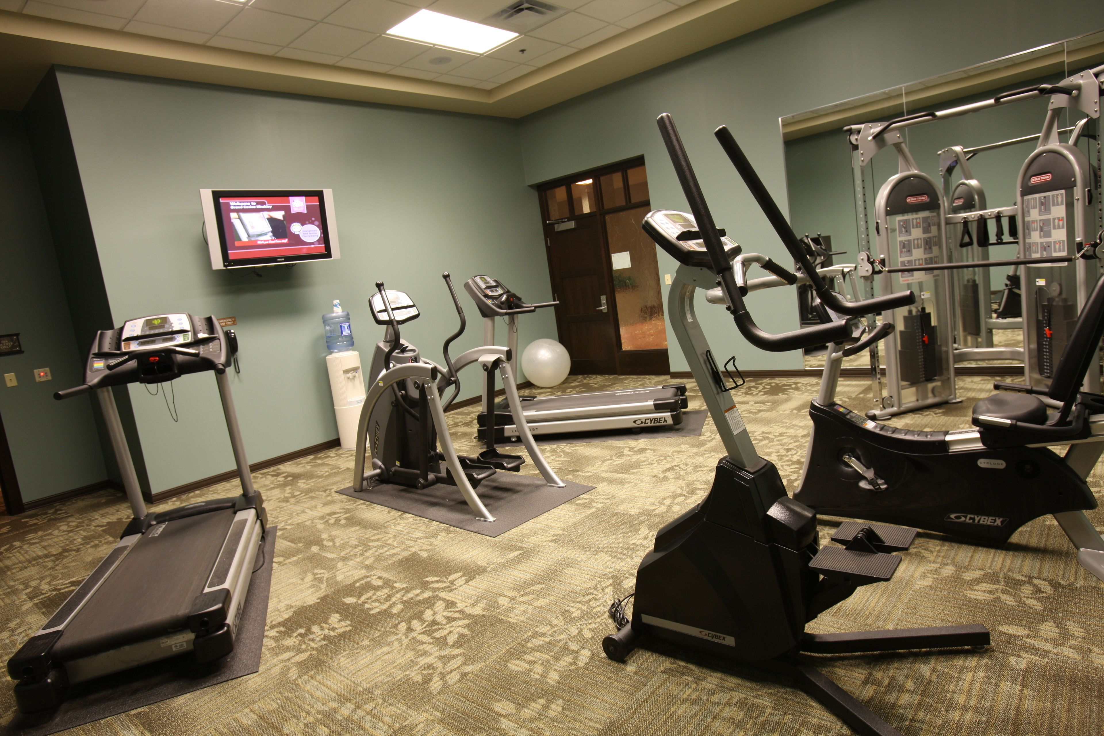 A gym with treadmills, elliptical machines, and weight machines.