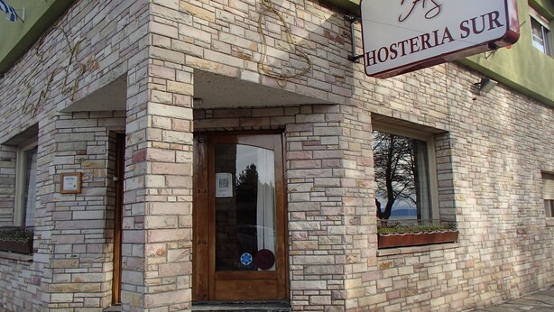 A brick building with a sign reading "HOSTERIA SUR". - Hosteria Sur (San Carlos de Bariloche)