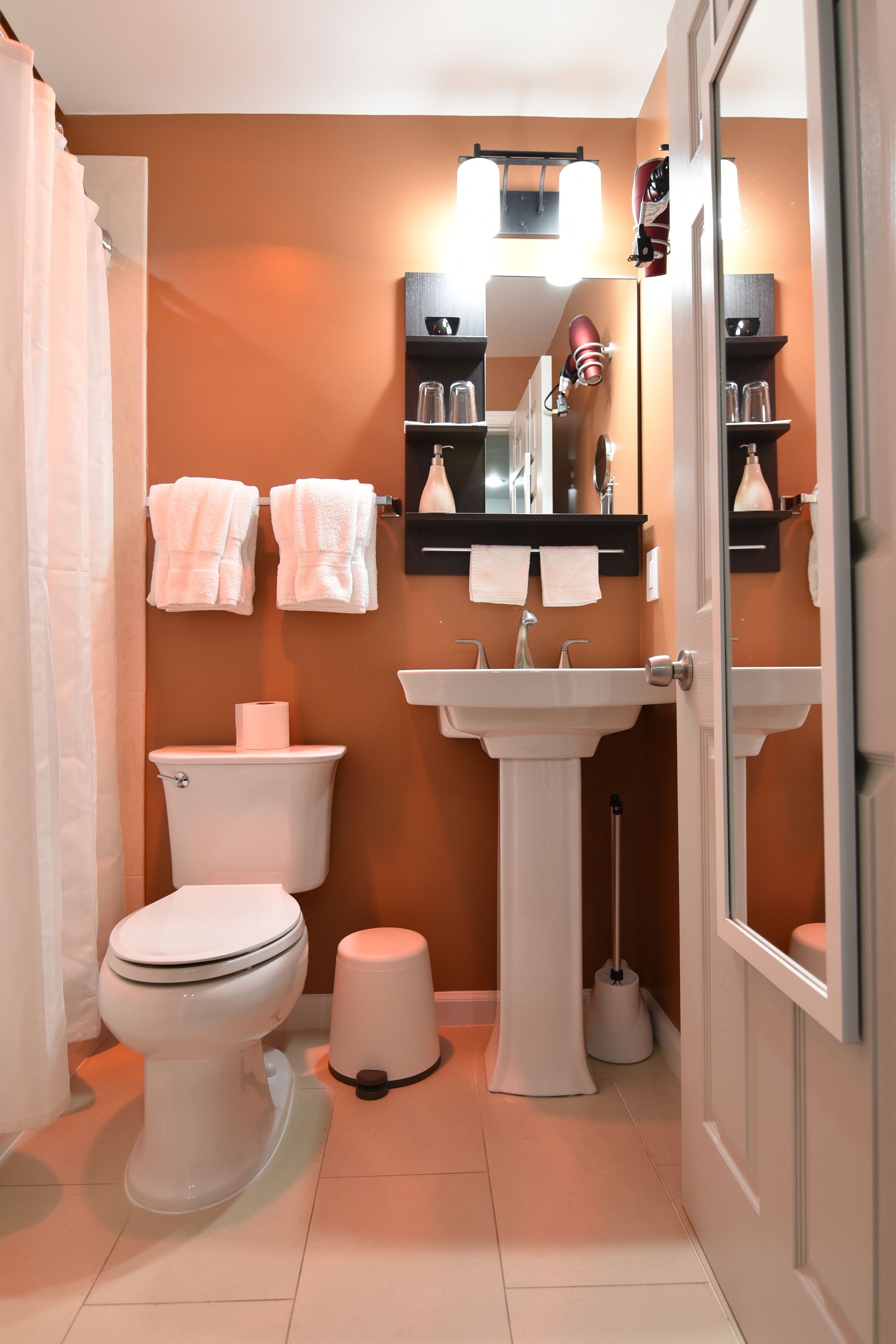 A bathroom with a toilet, sink, and two towel racks.