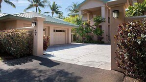 A residential area with a paved driveway, a garage, and palm trees. - Kumulani F 2 (Kamuela)