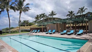 A swimming pool with lounge chairs and palm trees. - Kumulani F 2 (Kamuela)