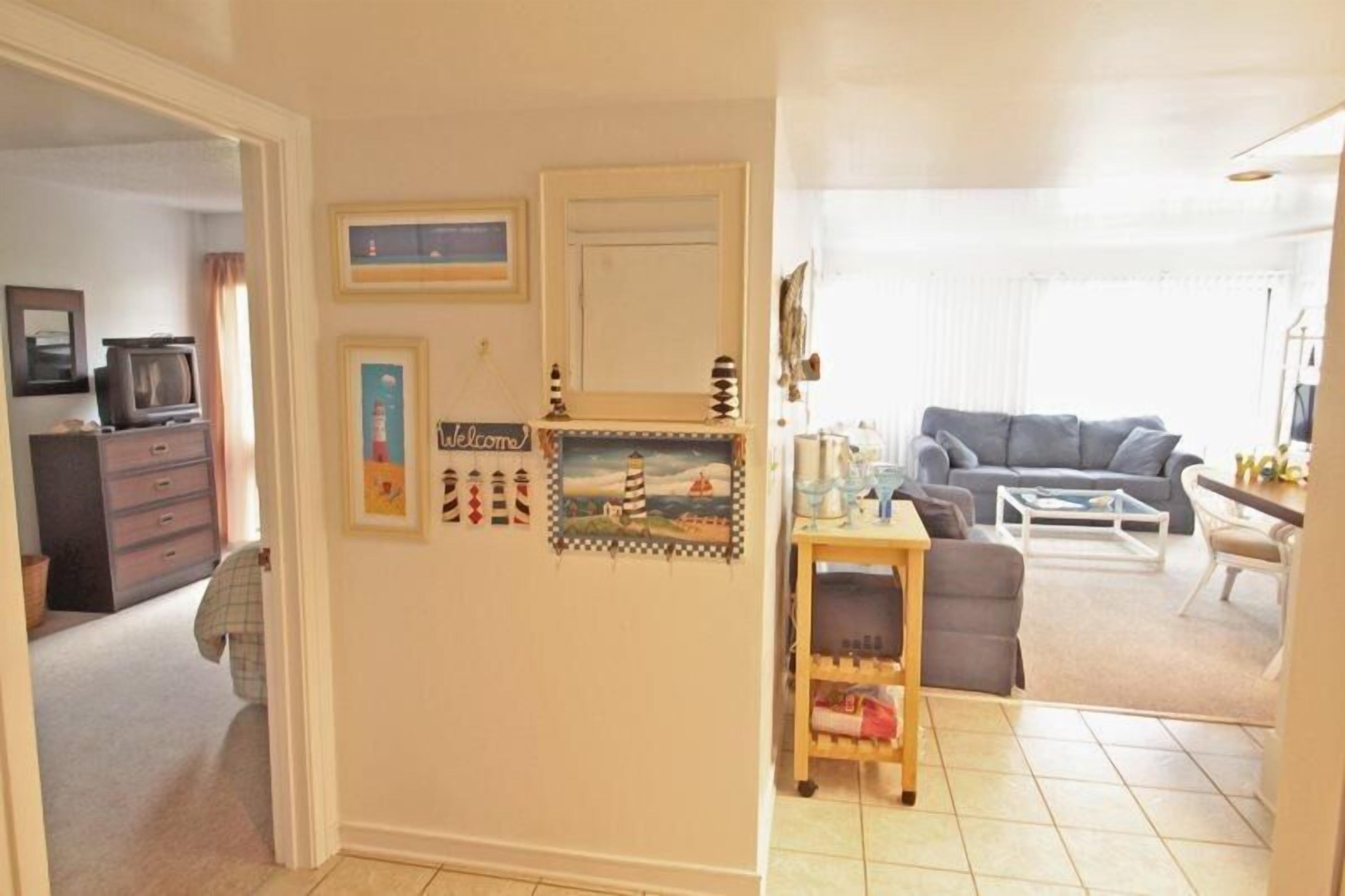 Een woonkamer met een grijze bank, een salontafel en een televisie in de hoek.