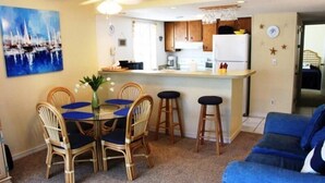 Un espace de vie compact comprenant un coin repas, une kitchenette et un canapé.