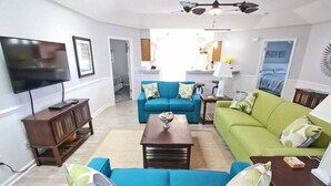 A living room with a TV, two sofas, a coffee table, and a ceiling fan. - Lake Arrowhead Recess (Myrtle Beach)