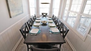 A dining room with a dark wooden table set for six, surrounded by black chairs. - Lake Arrowhead Recess (Myrtle Beach)
