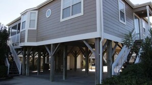 A two-story house with a covered porch supported by wooden stilts. - Lake Arrowhead Recess (Myrtle Beach)