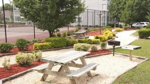 Un tavolo da picnic circondato da ghiaia e aiuole con arbusti vari.