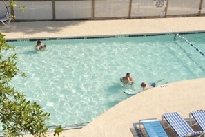 A swimming pool with clear water, surrounded by a fence and lounge chairs. - Lake Arrowhead Sanctuary (Myrtle Beach)