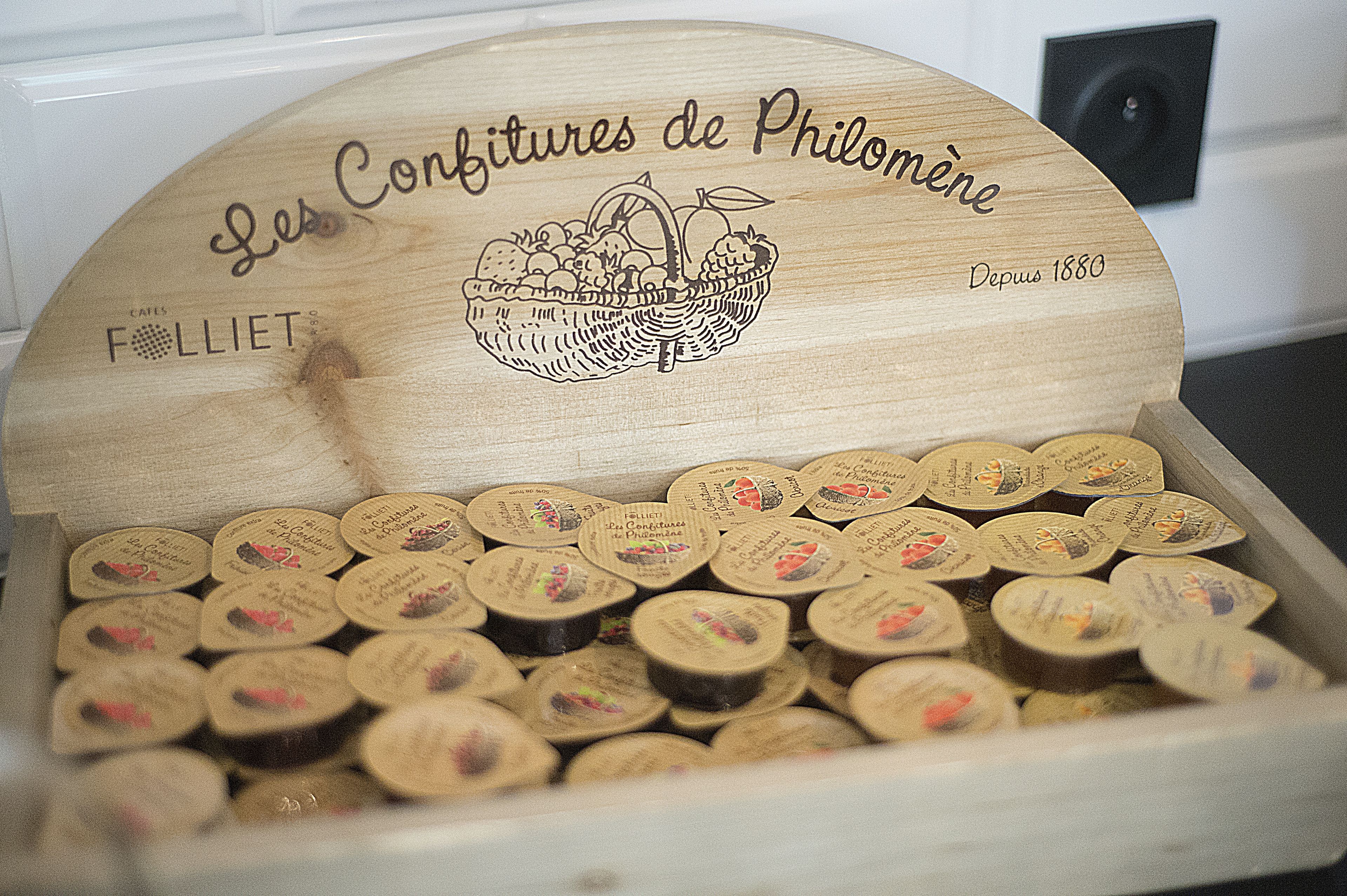 Une boîte en bois portant l’inscription « Les confitures de Philomène » et illustrée d’un panier.