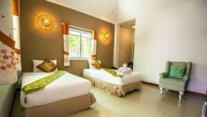 A hotel room with two beds, a chair, and a window with curtains. - Pai Sukhothai Resort (Sukhothai)