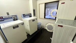 Un cuarto de lavandería con dos lavadoras, una ventana con vistas y un dispensador de agua.