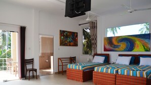 A hotel room with two beds, a desk, a chair, a TV, and a large window with a view of palm trees. - Hilltop Boosa (Boossa)