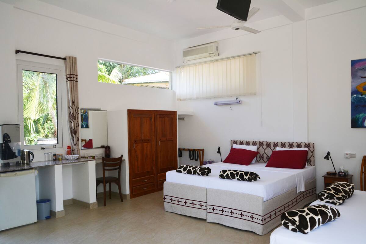 A bedroom with a bed, a desk, a chair, and a wardrobe.