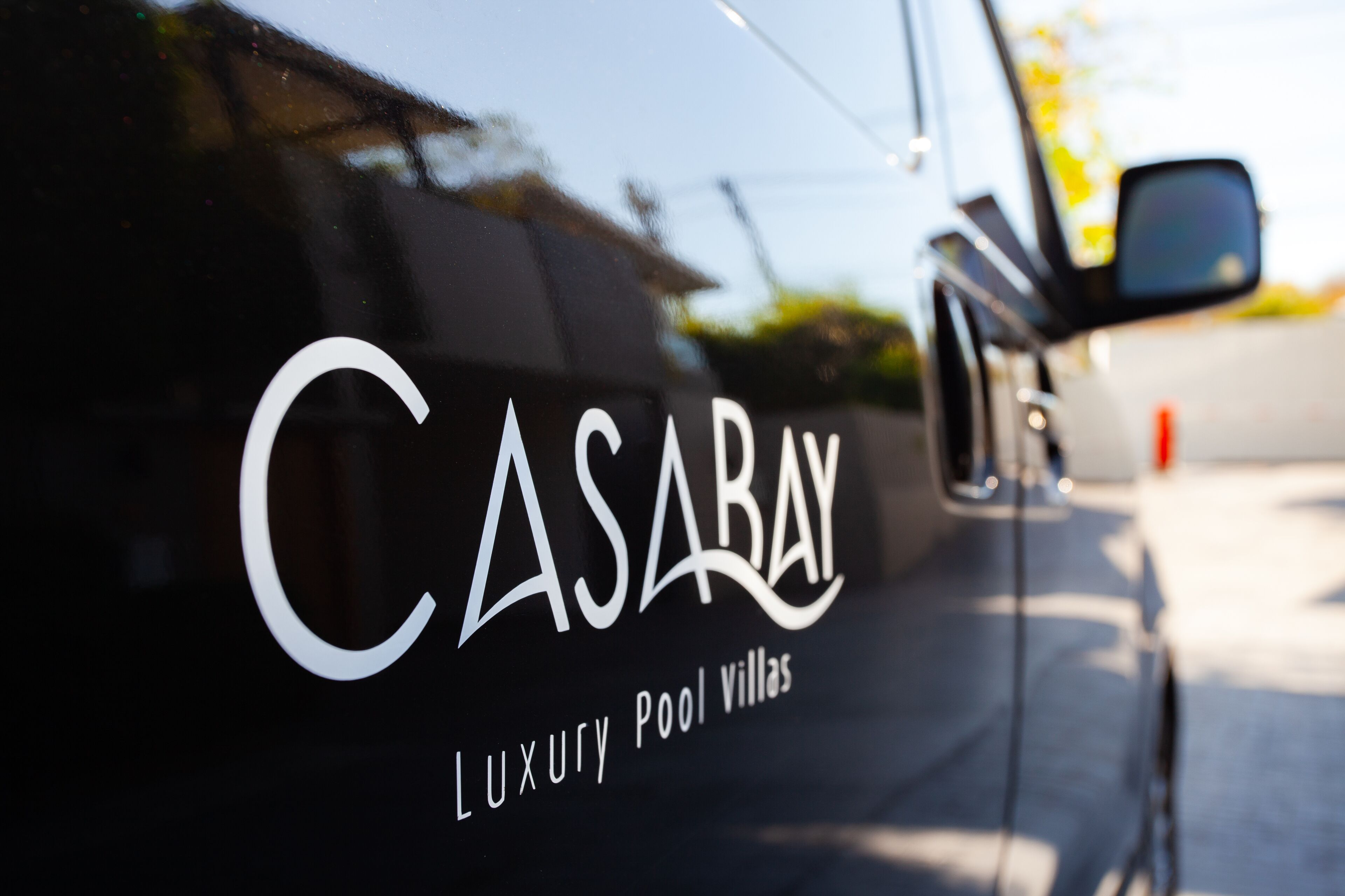 A luxury pool villa with a sleek design and a prominent logo.