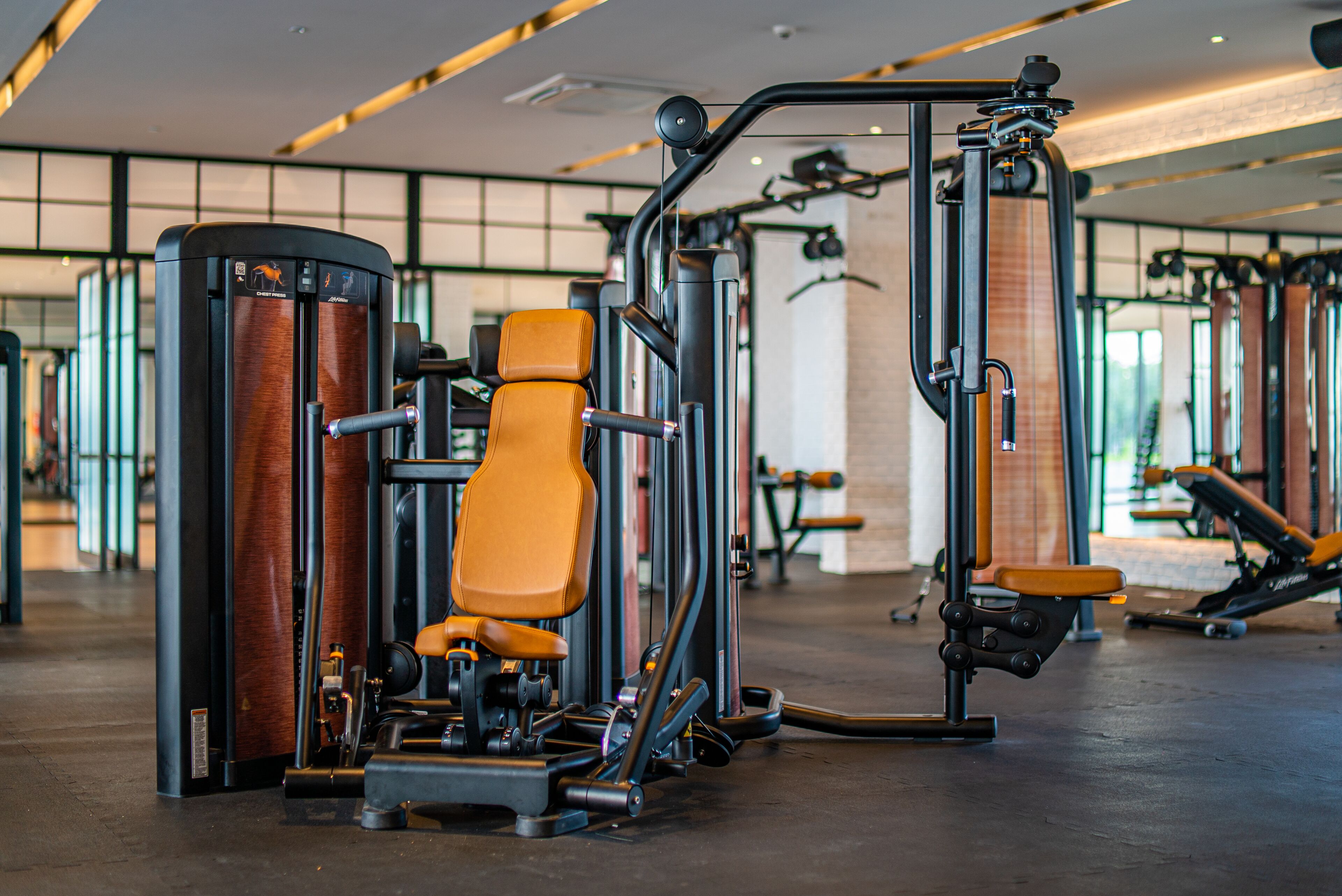Ein Fitnessstudio mit verschiedenen Trainingsgeräten, darunter eine Beinpresse und eine Brustpresse.