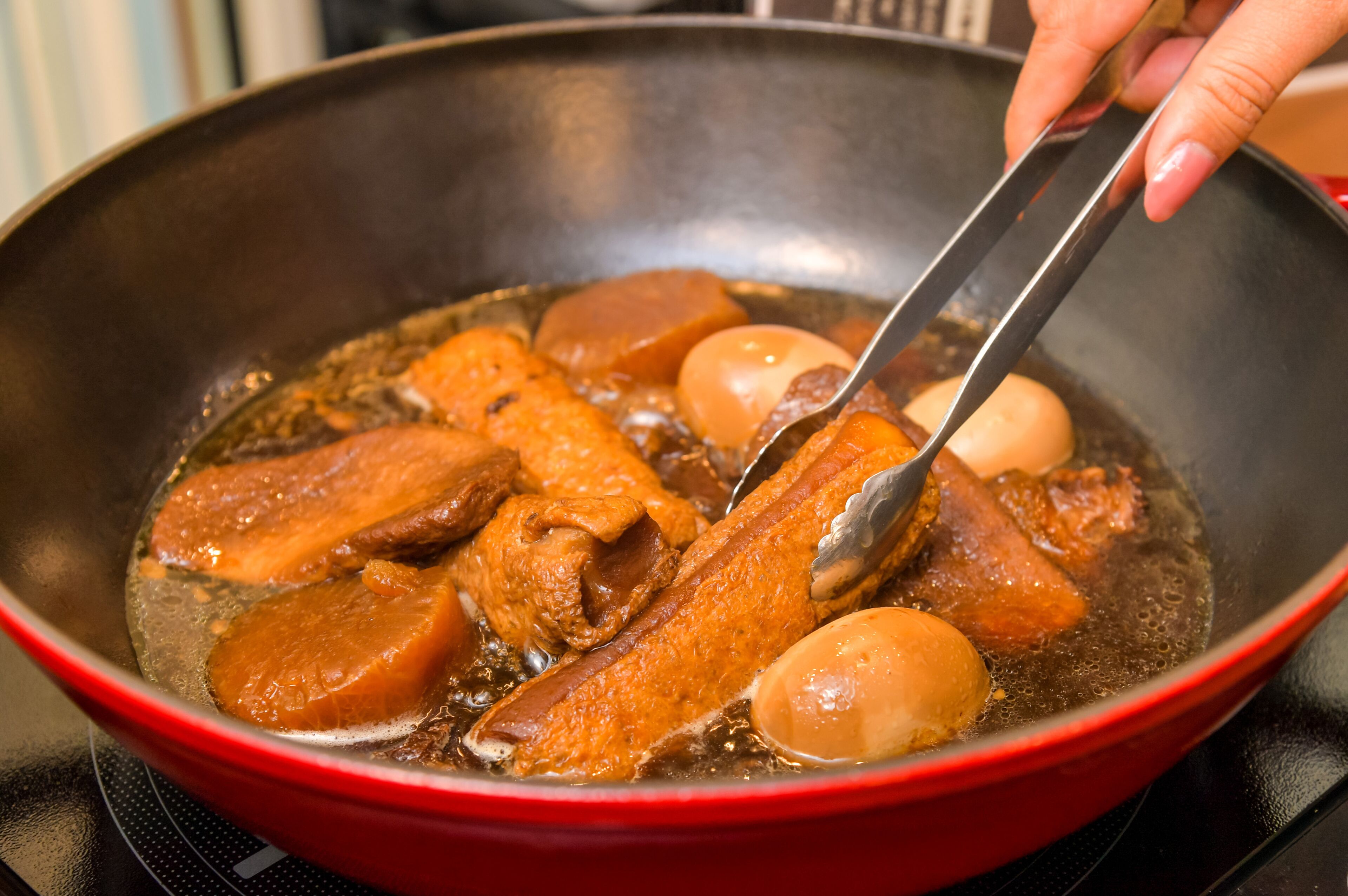 Gros plan d’une poêle dans laquelle on fait frire de la viande et des œufs.