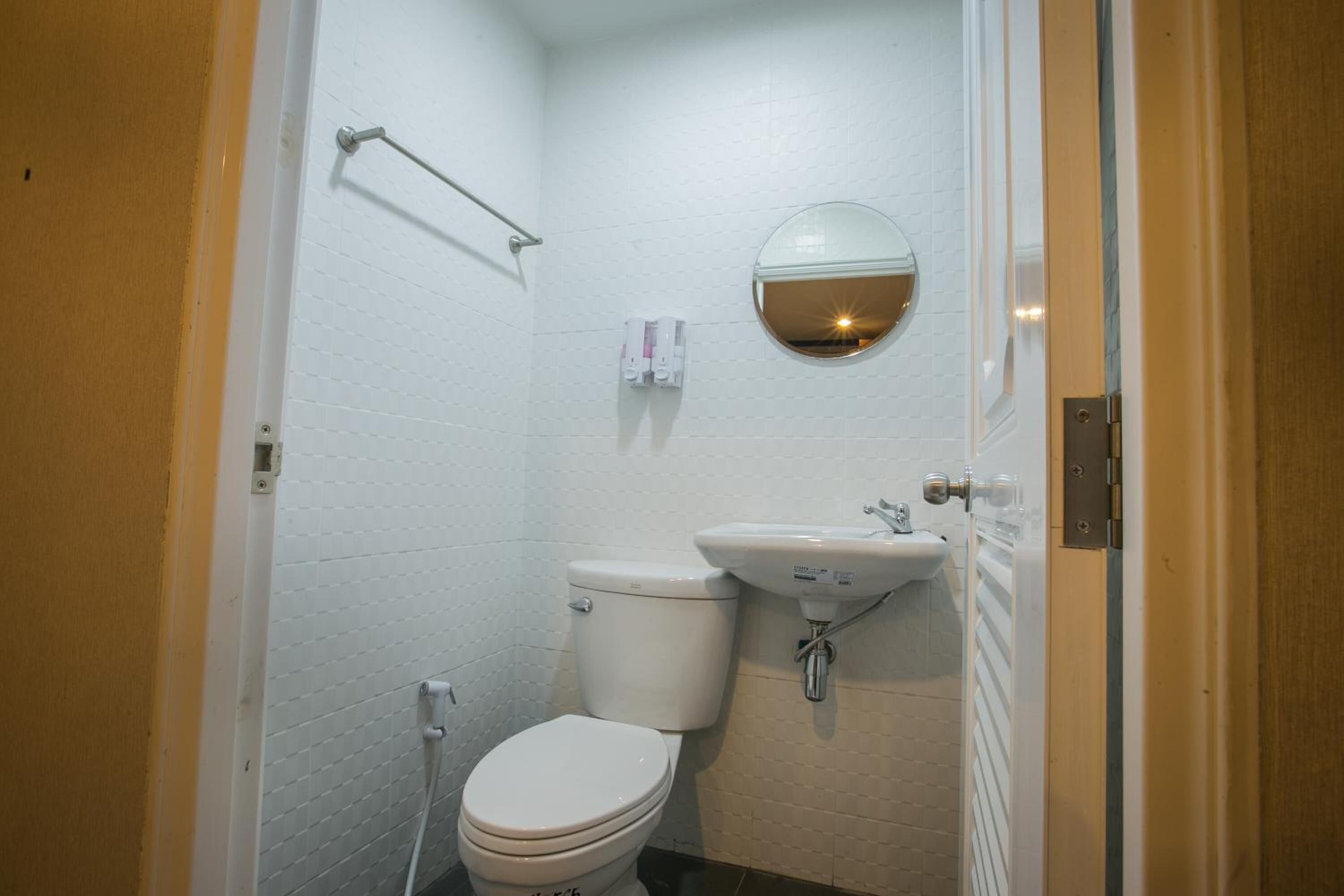 Un baño pequeño y funcional con inodoro, lavamanos y espejo.