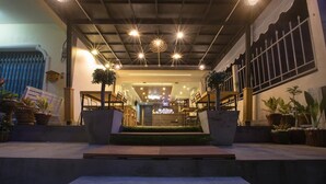 Entrada de un hotel con una escalera central que conduce a una zona de recepción.