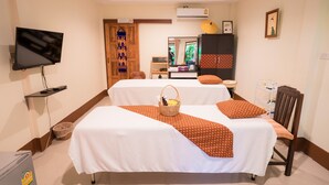 A hotel room with two beds, a television, a wardrobe, and a small table with a basket. - Gita's House (Chiang Rai)