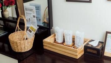 A reception desk with a wicker basket, a tray with glass tumblers, and a framed certificate on the wall.