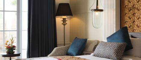 A neatly arranged hotel room with a bed, a bedside lamp, and a view through a window.