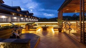 A modern outdoor seating area with a pool table, a motorcycle, and a bar area with wooden beams. - Plataran Heritage Borobudur Hotel (Borobudur)