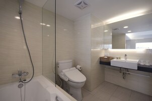 Een moderne badkamer met een badkuip, toilet en wastafel.