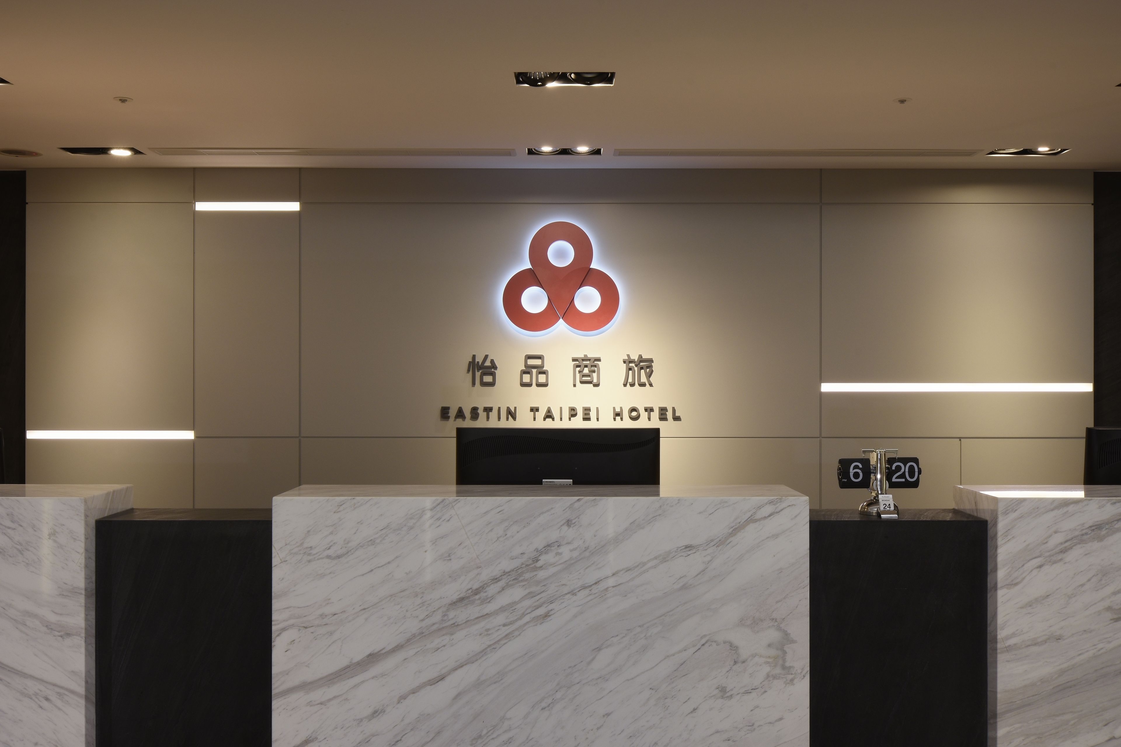 A reception desk with a logo and name of the Eastin Taipei Hotel.