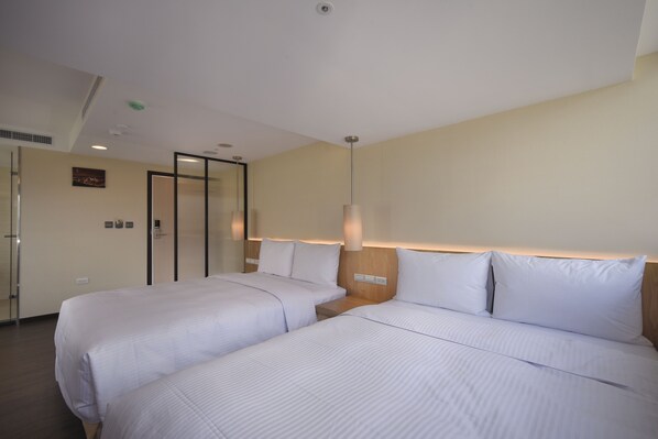 A hotel room with two beds, a wooden headboard, and a wall-mounted light fixture. - Eastin Taipei Hotel (Taipei)