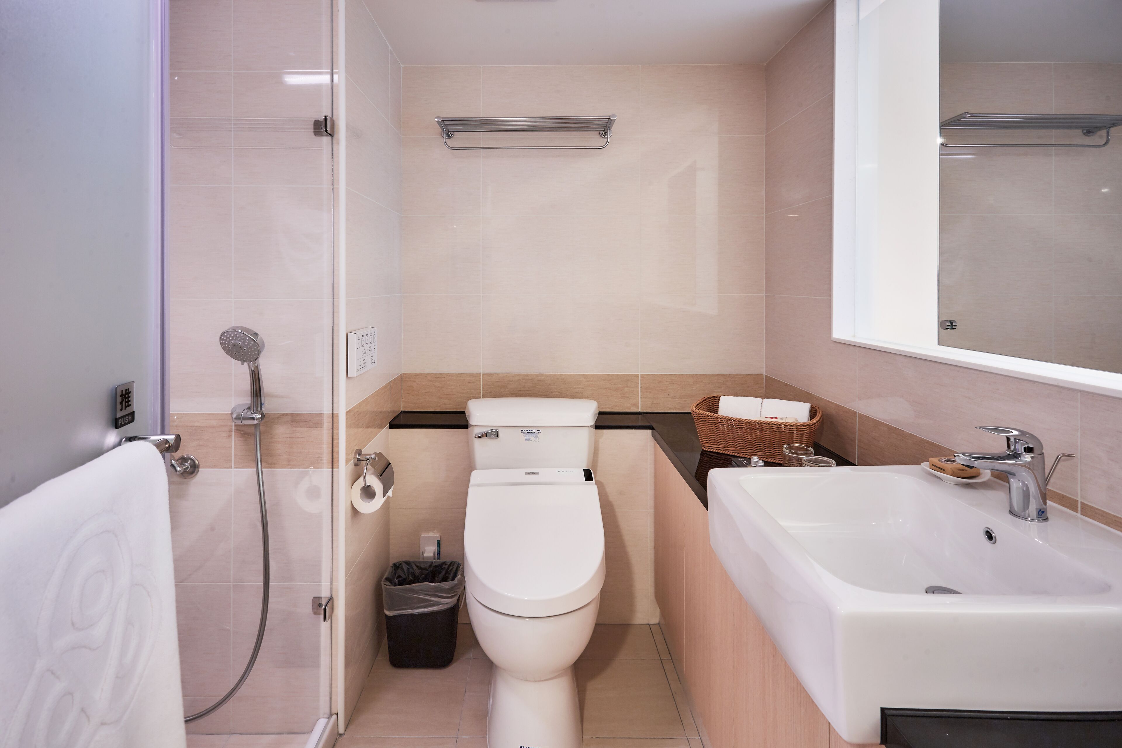 A modern bathroom with a toilet, bidet, shower, and sink.