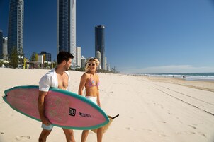 A beach with tall buildings in the background.